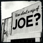 Stark black and white image of a sign painted directly on an outer wall. Wooden boards are visible next to it, and the top of a window frame below it. The sign reads 'How about a cup of' in cursive, and then in MUCH LARGER SANS-SERIF BLOCK LETTERS, 'JOE'.