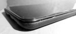 Edge-on view of the phone showing that the glass screen is splitting away from the plastic case.